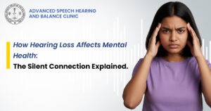 Young woman looking stressed, holding her head, representing the impact of hearing loss on mental health, with clinic branding in the background.